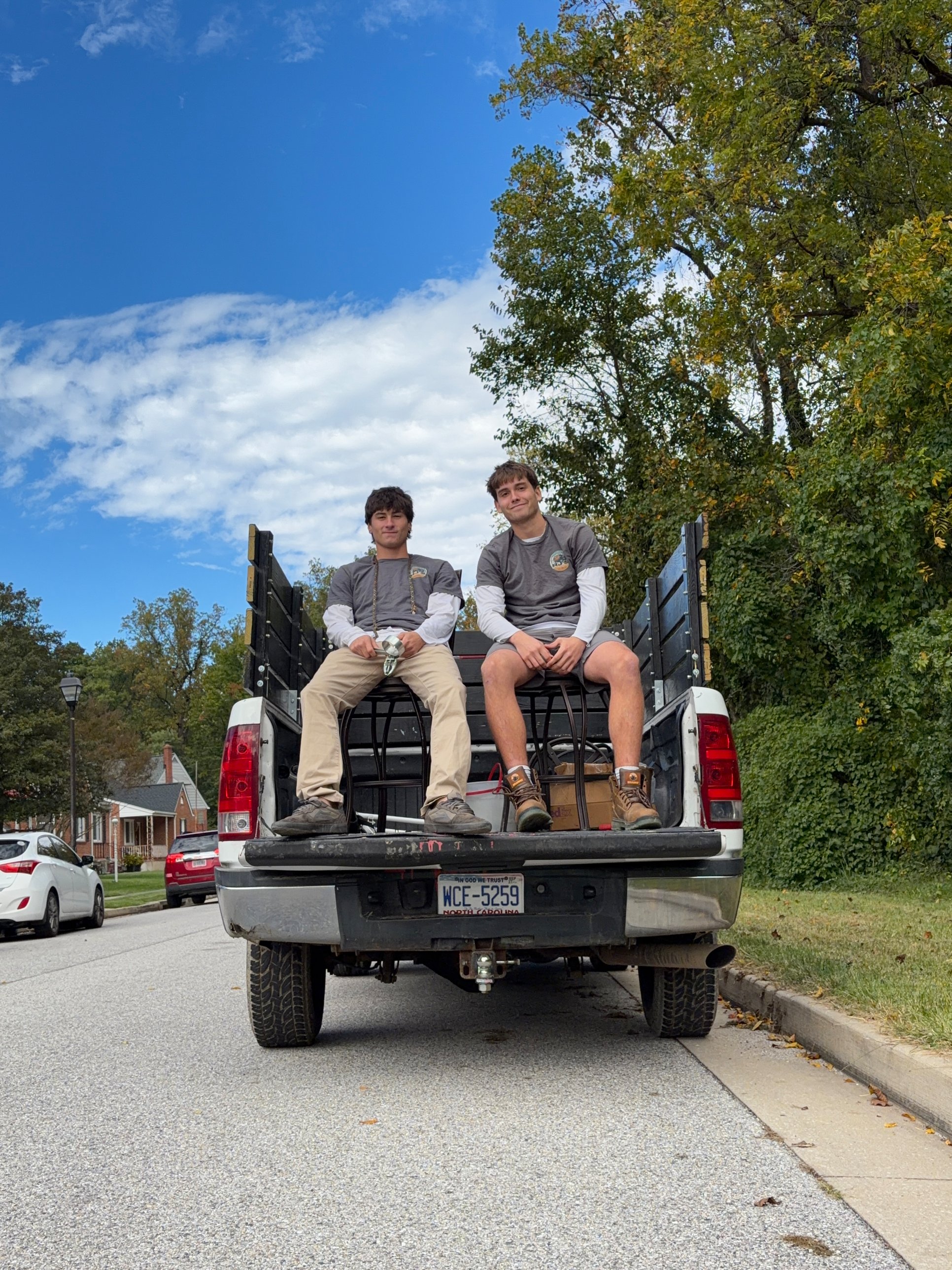 RJ's crew sitting on the tailgate of a fully loaded truck